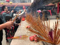 06B People offer incense joss sticks and fruit outside the main hall at Wong Tai Sin temple Hong Kong